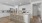 Kitchen with island/bar stools, white cabinets, pantry and subway tile backsplash