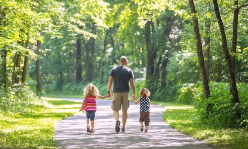 a family walking on trail in the woods